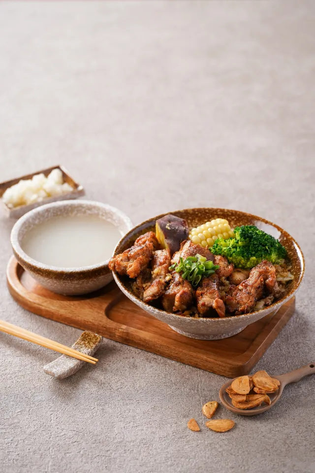煎得金黃的雞肉蓋在蛋炒飯上，配玉米、花椰菜與茄子