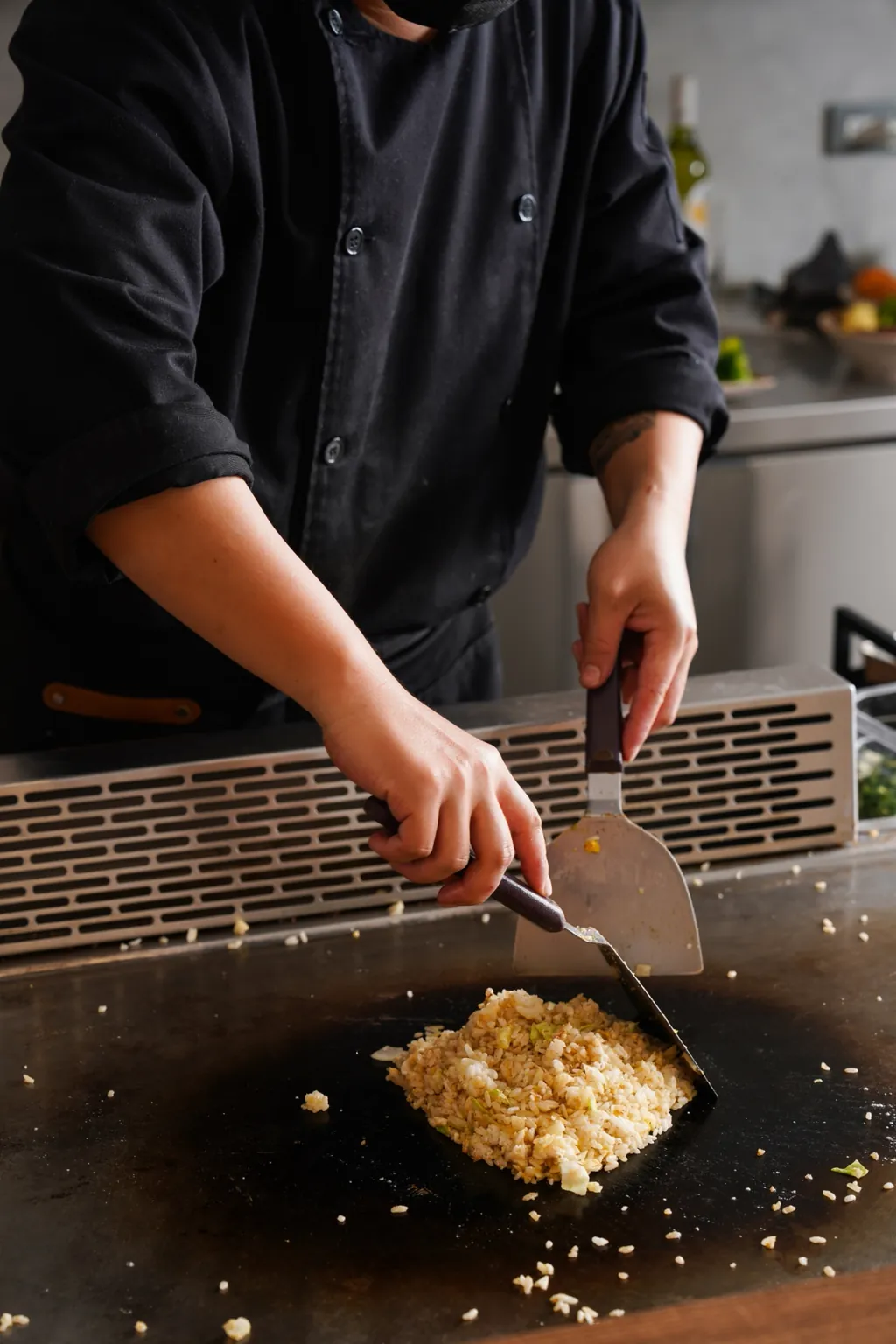 主廚用鏟子把炒好的飯收攏成一份