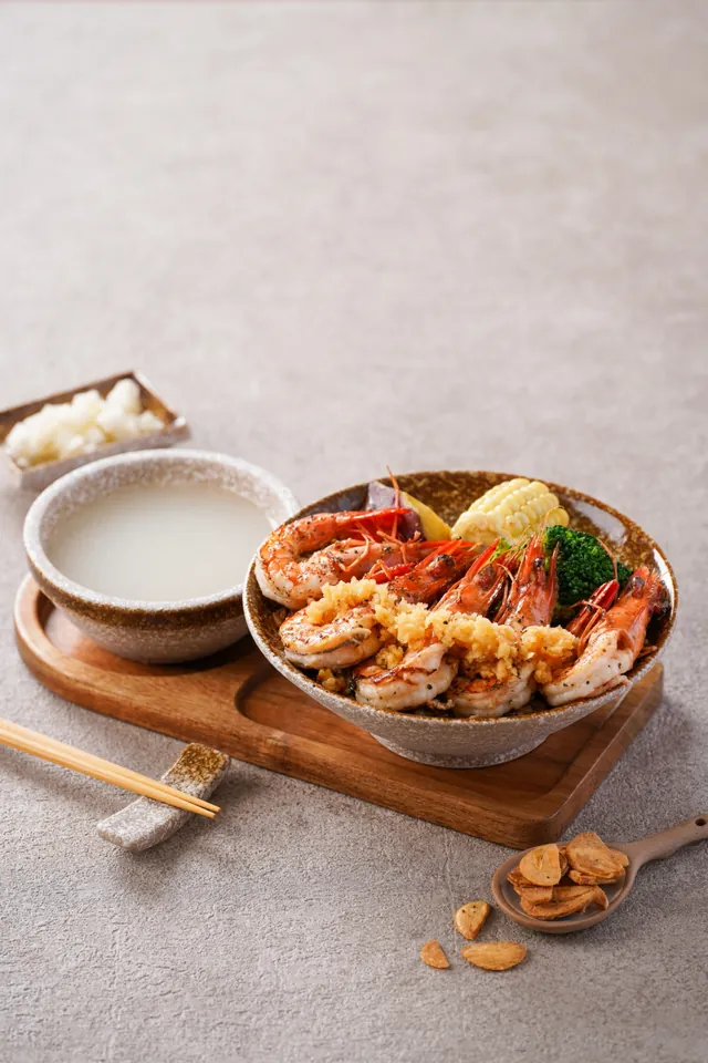 去殼大草蝦蓋在蛋炒飯上，旁邊是雞湯與醃蘿蔔